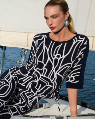 Model im schwarz-weißen Kleid auf Boot